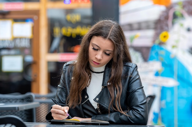 Jeune femme écrivant sur un livre à la maison
