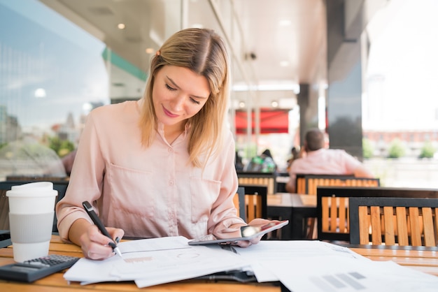 Portrait de jeune femme d'affaires travaillant avec une tablette numérique au café. Concept d'entreprise.